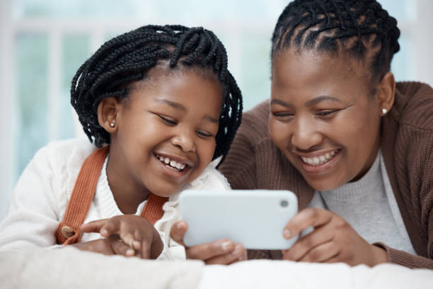 istock Shot of a young mother lying on the bed with her daughter and bonding while using a cellphone 1352858310