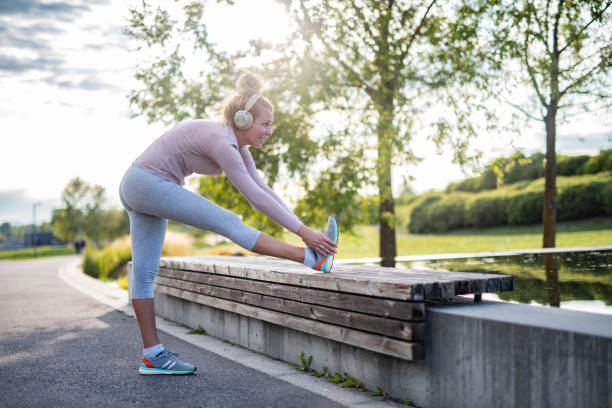 istock Woman stretching her leg at the bench 1352860091