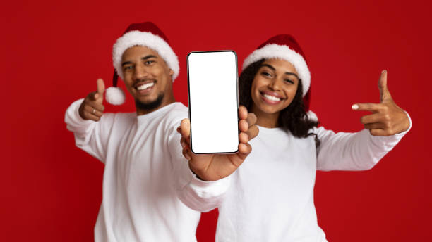 istock Positive african american lovers showing cellphone with empty display 1352860165