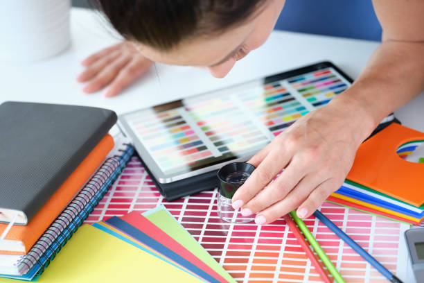 mujer diseñadora mira a través de la lupa a la paleta de colores con diferentes tonos de colores - swatch spectrum multi colored document fotografías e imágenes de stock