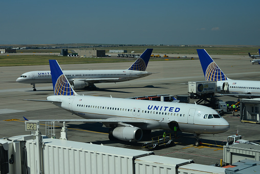 Denver, Colorado, USA: three United Airlines (Star Alliance) aircraft at Concourse B of Denver International Airport - in the center Airbus A320-232 N489UA, MSN 1702. Boeing 757 on the taxiway and tail of another Boeing 757 on the right.