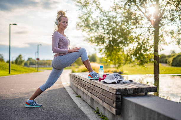 istock Woman stretching her leg at the bench 1352865510