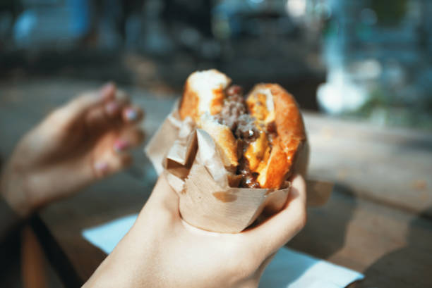 istock Woman eating burger outdoor 1352866421