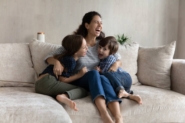 istock Overjoyed young hispanic mother having fun with laughing small kids. 1352867553