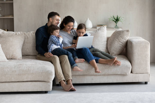 istock Happy affectionate loving hispanic family using computer at home. 1352867557