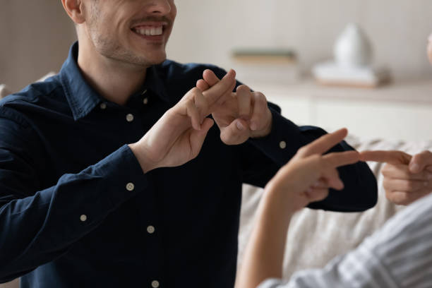istock Close up cropped image smiling young couple using sign language. 1352867569