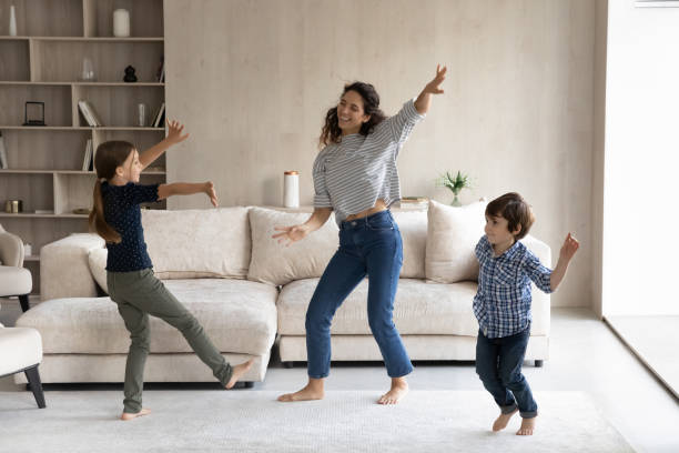 istock Young hispanic mother dancing with small children. 1352867645