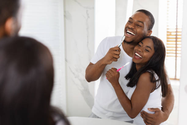 istock Cheerful African American Couple Having Fun While Brushing Teeth In Bathroom Together 1352867828