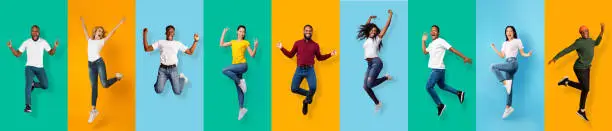 Full length of happy energy international young students jumping from success, victory, isolated on colorful background, panorama, copy space. Smiling excited people celebrating win, have fun and joy