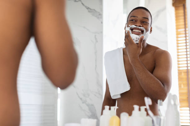 istock Shirtless Black Guy Looking At Mirror And Applying Shaving Foam In Bathroom 1352874230
