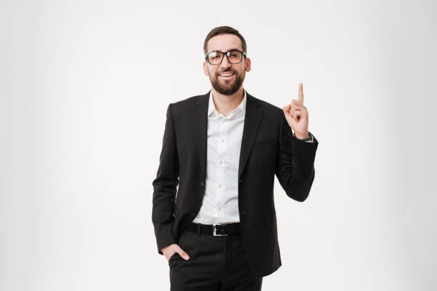 istock Handsome young bearded businessman wearing glasses pointing to copyspace. 1352874405