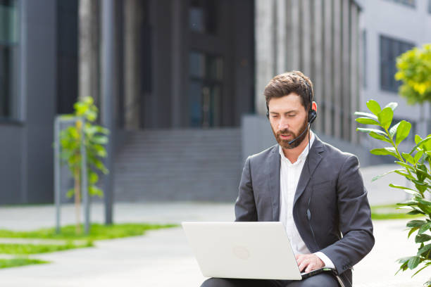 istock Successful freelancer man conducts online consultation uses a headset with a microphone and a laptop for video communication 1352875044
