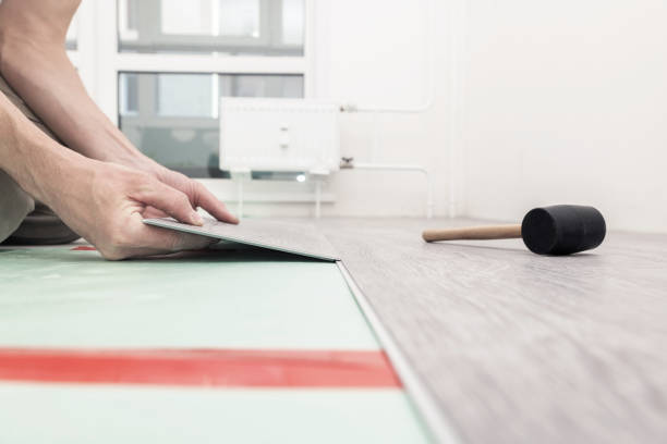 istock Man lays a quartz laminate on the floor. 1352878564