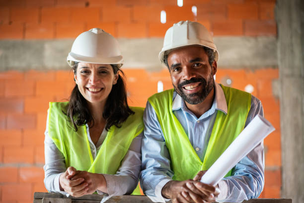 istock Portrait of a two happy construction workers at building site 1352878568