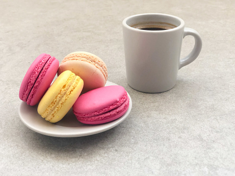 closeup of colorful macaroons and cup of coffee on the table with copy space. selective focus