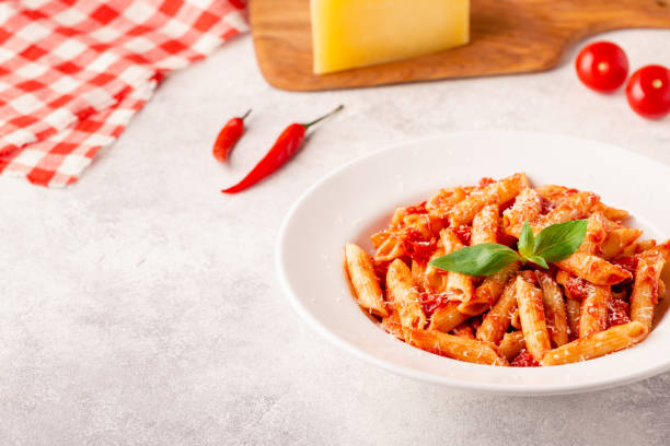 istock Classic italian pasta penne alla arrabiata with fresh basil on a light background, selective focus 1352878815