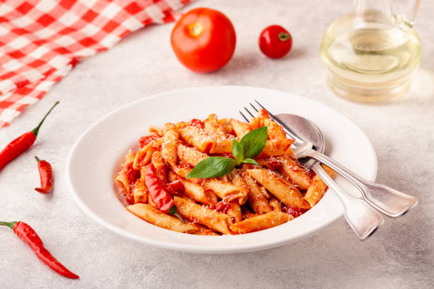 istock Classic italian pasta penne alla arrabiata with fresh basil on a light background, selective focus 1352878816