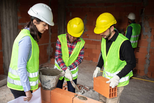 istock Architect monitoring the bricklaying working at construction site 1352879870