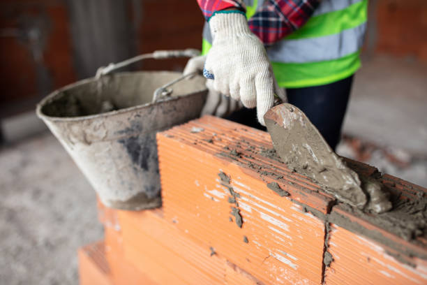 istock Close-up of a bricklayer building a wall at the construction site 1352880191