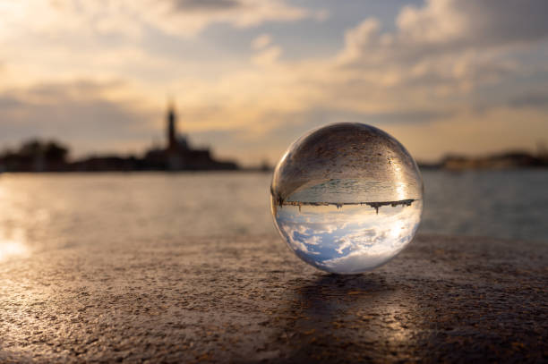 Glass ball lying on a bollard in Venice (Italy), sunset near sea