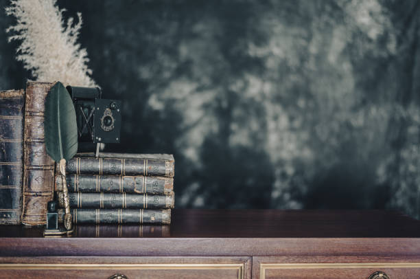 istock Old antique books on a library desk lit in the dark. 1352882469