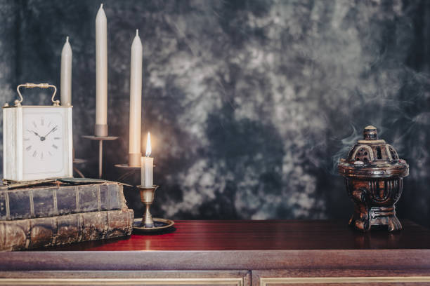 istock Old antique books on a library desk lit in the dark. 1352882532