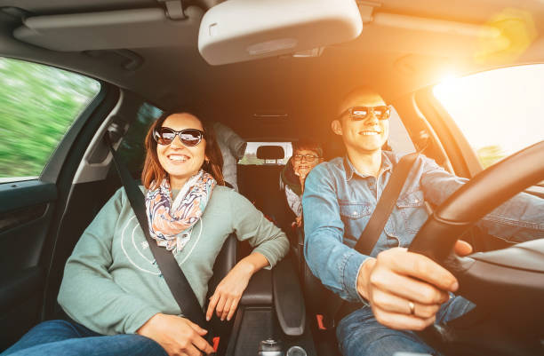 jeune famille traditionnelle a un long voyage en voiture et chante joyeusement à haute voix la chanson préférée ensemble. concept de voiture de sécurité grand angle à l’intérieur de l’image de vue de voiture. - road trip photos et images de collection