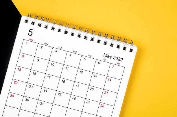 istock May 2022 desk calendar on yellow and black background. 1352889311
