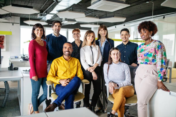 retrato de un grupo de hombres y mujeres multirraciales de pie en la oficina - business looking at camera office new fotografías e imágenes de stock