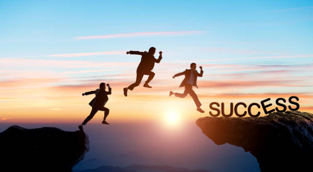 istock Businessman jumping to success cliff 1352892501