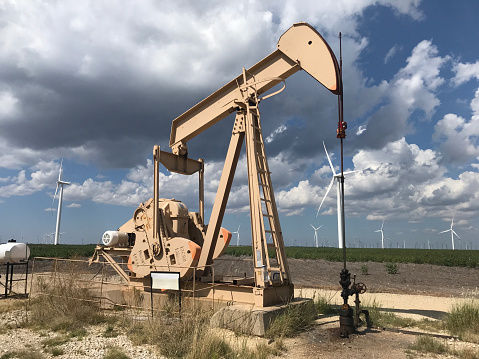 Countless wind-powered Western-style vehicles along a rural highway in Texas.Although it was an area where the oil industry was active, wind power generation is increasing due to the recent trend of Decarbonization.Dark Image.