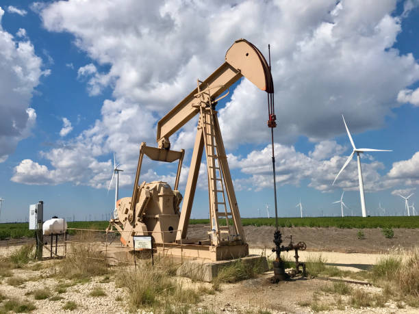 Oil drilling pumps and wind turbines. Countless wind-powered Western-style vehicles along a rural highway in Texas.Although it was an area where the oil industry was active, wind power generation is increasing due to the recent trend of Decarbonization. oil well stock pictures, royalty-free photos & images
