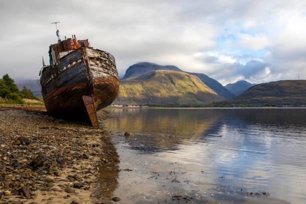 la vecchia barca naufragata di caol con ben nevis in scozia, regno unito - ben nevis nevis ben loch foto e immagini stock