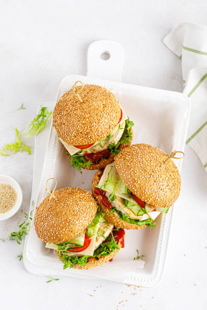 istock Hamburger with grilled chicken burger, fresh cucumber, tomato, cheese and lettuce. Top view. 1352898219