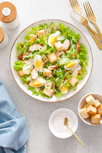 caesar salad con petto di pollo alla griglia, uovo sodo, crostini, parmigiano, insalata verde lattuga e condimento - crostini foto e immagini stock