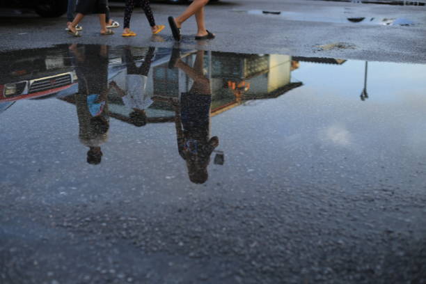 istock Wet parking spaces after hard rain fall with reflection in puddle on the ground. 1352901408