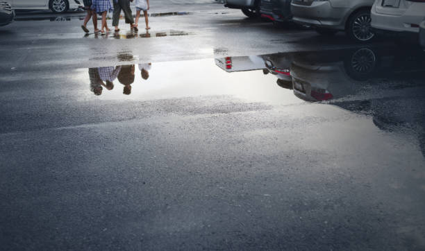 Wet parking spaces after hard rain fall with reflection in puddle on the ground.Selective focus.