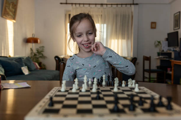 istock Girl playing game of chess 1352904359