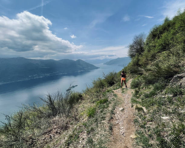 istock Young woman runs along mountain ridge above lake 1352906487