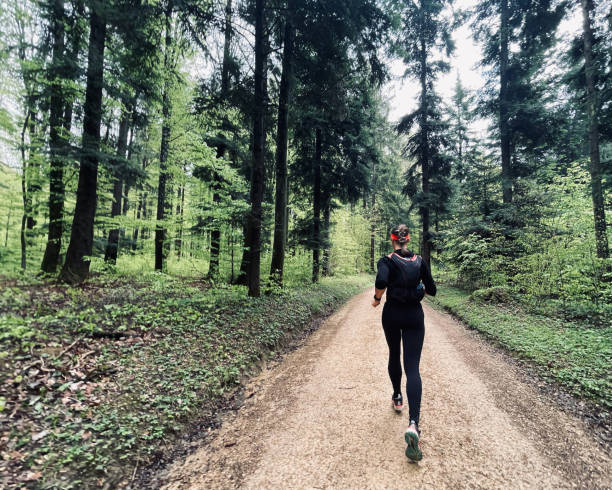 istock Young woman runs through lush forest 1352906491