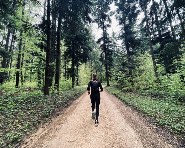 istock Young woman runs through lush forest 1352906510