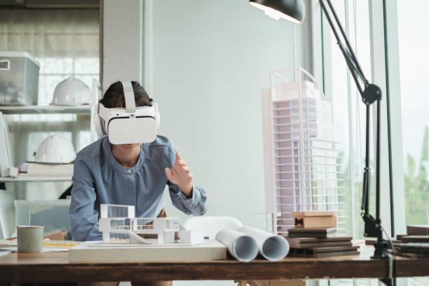 istock Architect wearing virtual reality headset for detail project house model. 1352906625