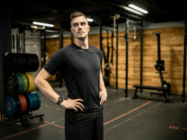 istock Young Man taking a break from  lifting weights in the Gym 1352909454