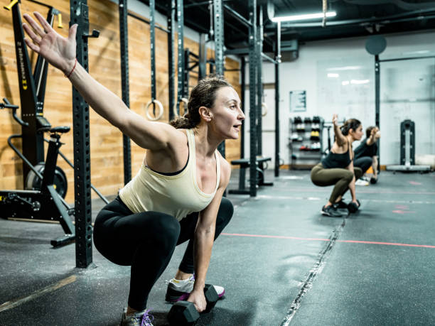 istock Women lifting weights in the Gym 1352910260