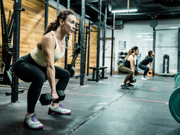 istock Women lifting weights in the Gym 1352910299