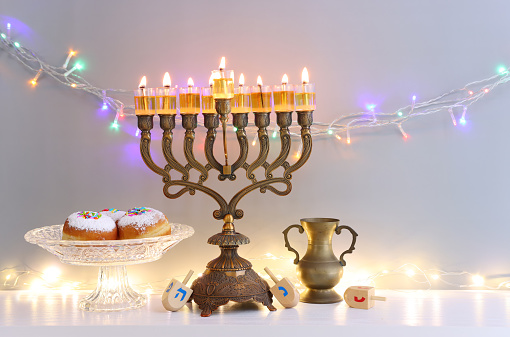 Religion image of jewish holiday Hanukkah background with menorah (traditional candelabra), doughnut and candles