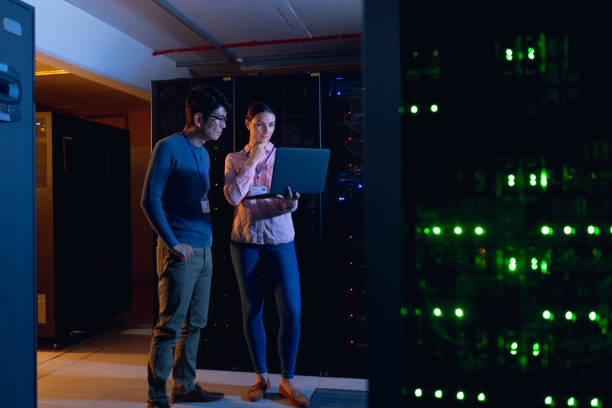 istock Diverse male and female engineers using laptop in computer server room 1352913980