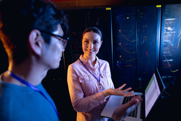 istock Diverse male and female engineers using laptop in computer server room 1352914003