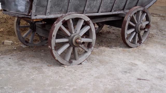 An old wooden cart stands in a village courtyard.