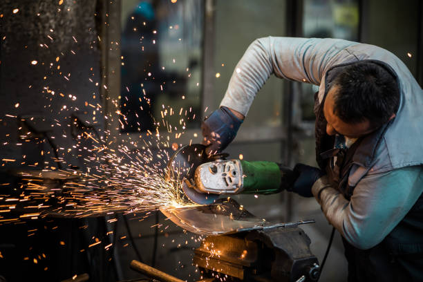 istock Heavy industry worker cutting steel with an angle grinder. 1352917480